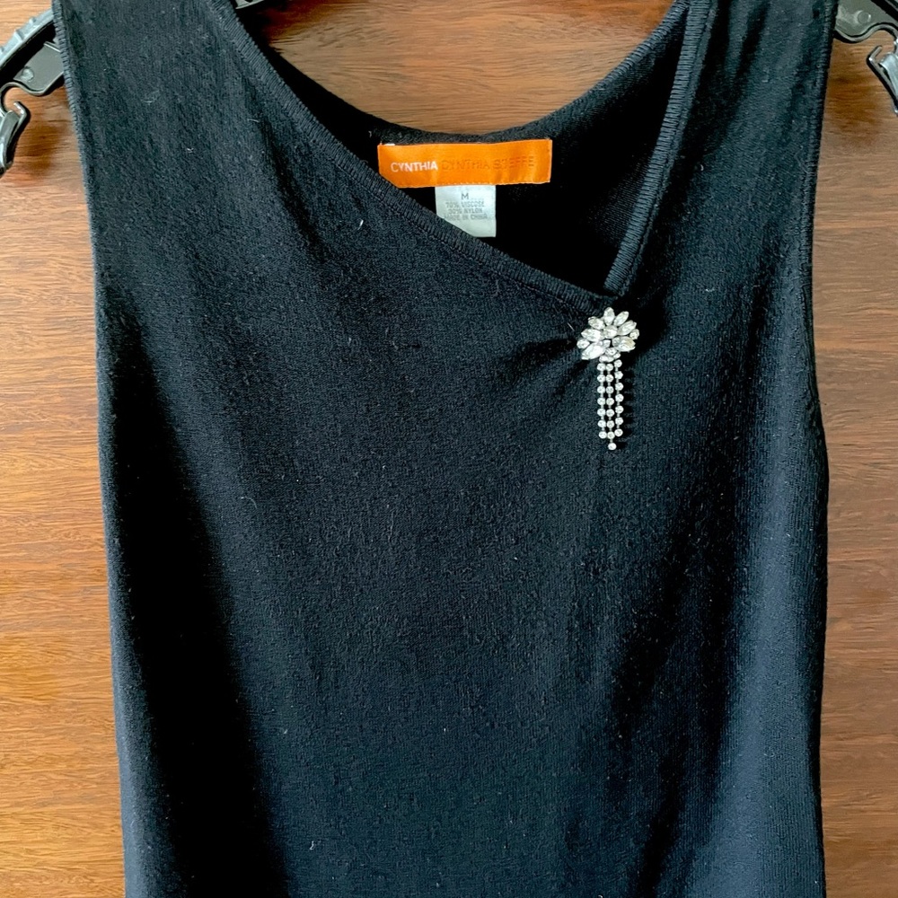 Women’s sleeveless light weight  knit with brooch.